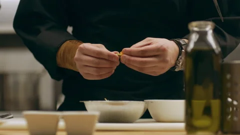 Professional chef removing petals from an orange flower for garnish in industria Stock Footage 199463268