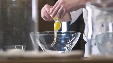 Professional Chef in Restaurant Kitchen breaks Eggs. Delicious healthy Food. 库存影片 143415596