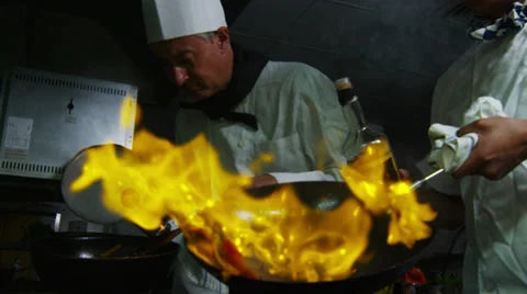 Professional chef in a restaurant kitchen cooking flambe style Stock Footage 31885172