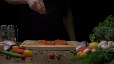 Professional chef salting red fish steak Stock Footage 205836065