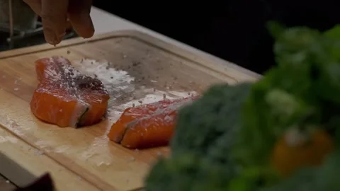 Professional chef salting red fish steak Stock Footage 205837308