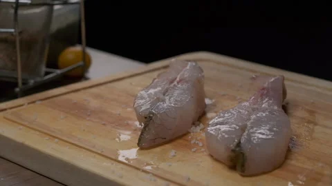 Professional chef salting white fish steak Stock Footage 205913037