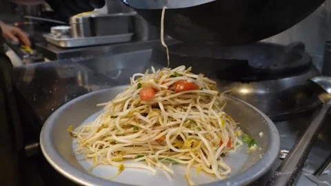 Professional Chef Sautéing and Plating Fresh Asian Stir-Fried Noodles in Commerc Video stock 332815174