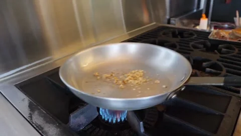 Professional Chef Sautéing Minced Garlic in Stainless Steel Pan for Authentic It Stock Footage 337677491