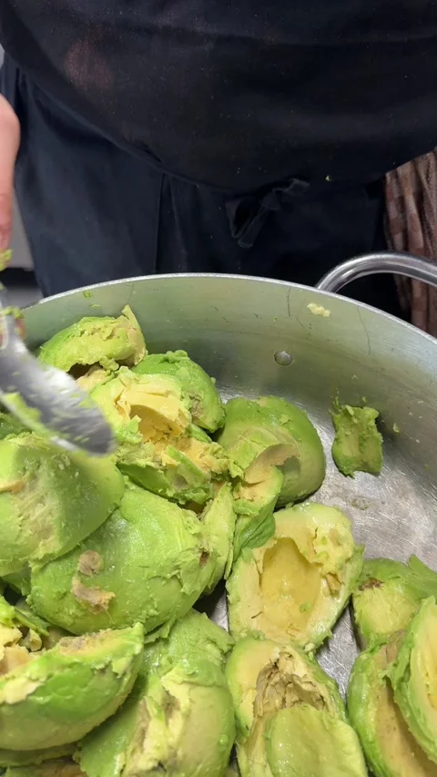 Professional Chef Scooping Avocado Pulp to Prepare Fresh Guacamole Stock Footage 327265711