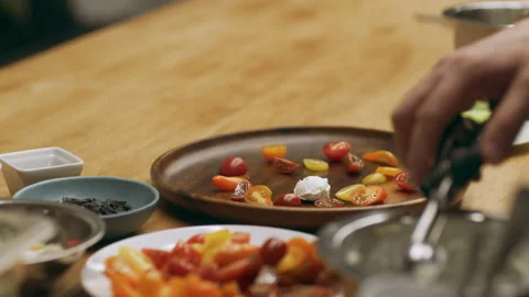 Professional chef scooping ricotta cheese onto a wooden plate with tomatoes for Video stock 199458809
