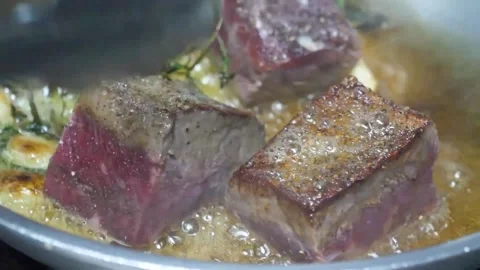 Professional Chef Searing Juicy Beef Steak with Tongs in a Hot Frying Pan - Trad Stock Footage 337678414