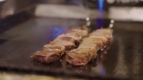 Professional Chef Searing Premium Wagyu Beef Skewers with Blowtorch on Teppanyak Stock Footage 337440996