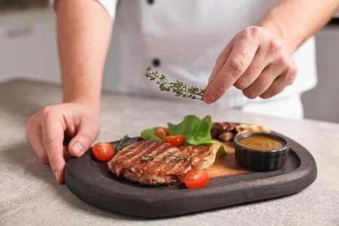 Professional chef serving dish at table indoors, closeup Stock Photos