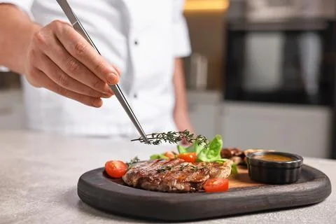 Professional chef serving dish at table indoors, closeup Stock Photos