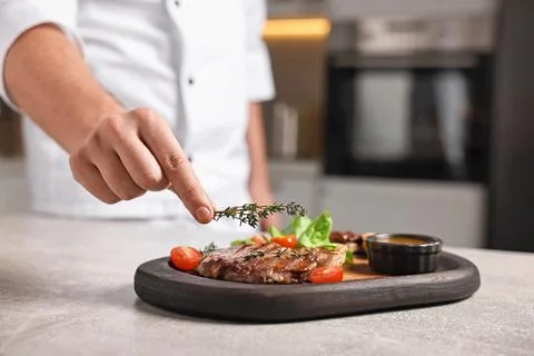 Professional chef serving dish at table indoors, closeup Stock Photos