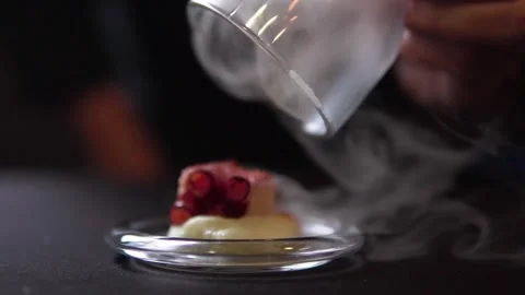 Professional chef serving tapas of smoked octopus on glass hood. Stock Footage 269065764