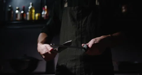 Professional chef is sharpening his knife before cooking a meal. Cool cooker is 库存影片 144449597