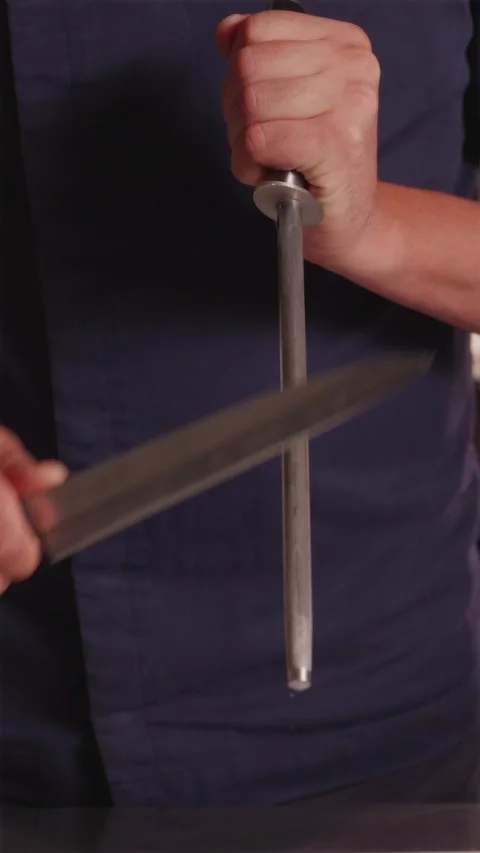 Professional chef sharpening steel kitchen knife with whetstone Stock Footage 337119187