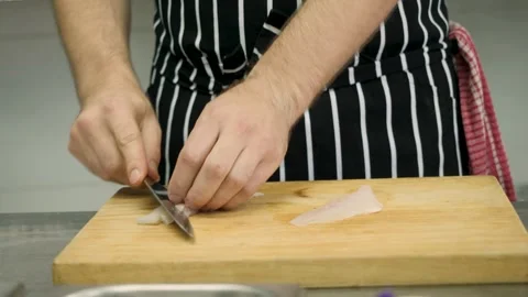 Professional chef slices raw white fish with a knife in close-up, thin slices. A Stock Footage 262797108