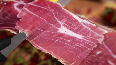 Professional chef slicing cured prosciutto leg with sharp knife, extra high Stock Footage 302088839