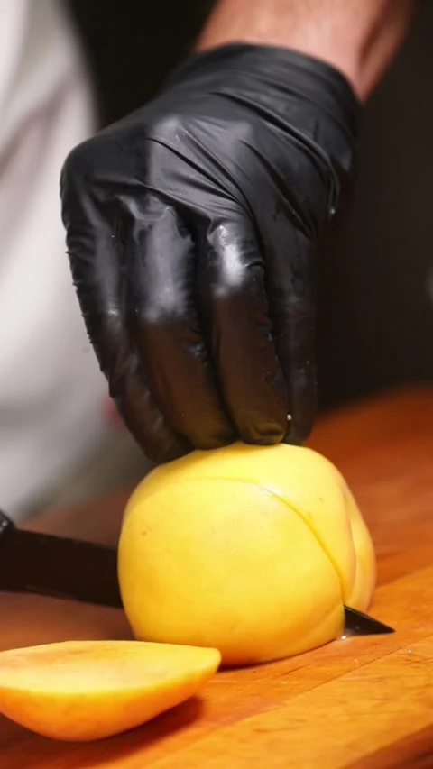 Professional chef slicing a fresh peach on a wooden cutting board. Stock Footage 335653538