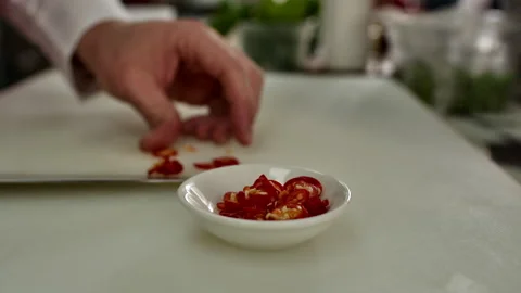 Professional Chef Slicing Fresh Red Chili Peppers into a Bowl Stock Footage 328744971