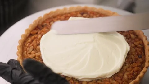 Professional Chef Spreading Thick Whipped Cream over Freshly Baked Pecan Pie Stock Footage 337751506