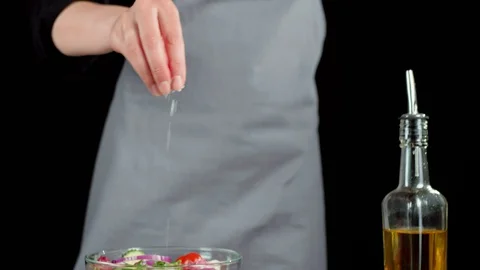 Professional chef sprinkles a ready-made summer salad with sea salt Stock Footage 129746498