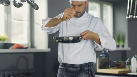 Professional Chef Squeezes Lemon Juice onto Hot Pan with Red Fish Fillet on it.  Stock Footage