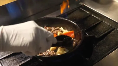 Professional Chef Stir-Frying Beef with Fresh Bell Peppers and Onions in a Wok Stockbeeldmateriaal 337678882