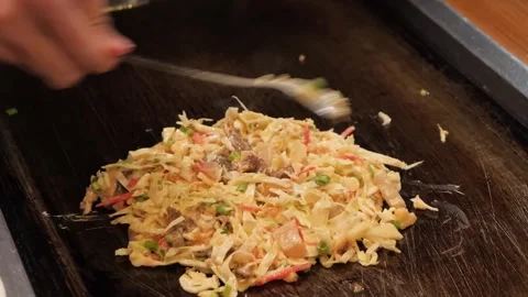 Professional Chef Stir-Frying Savory Monjayaki on Teppan Grill Stock Footage 333600218