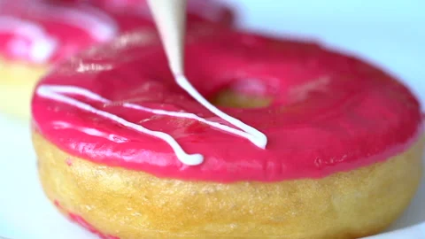 Professional chef technologist decorates freshly made and oily doughnut with cri Stock Footage 199489256