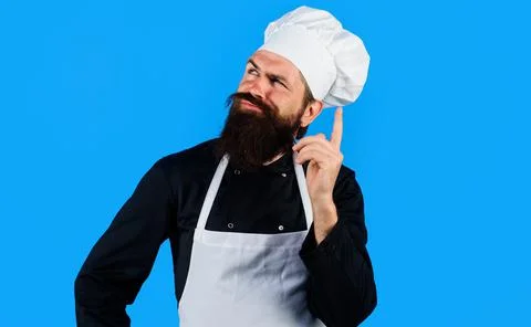 Professional chef in uniform composing new menu. Bearded cook in hat and apro Stock-Fotos