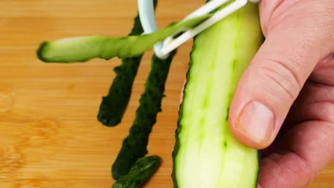 A professional chef uses a white peeler to remove the green skin. Video stock 341540888