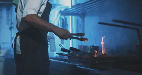 Professional chef using fire grill in professional kitchen Stock Footage 203556137
