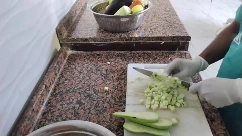 Professional chef in white gloves chopping red onions and tomatoes on Stock Footage 330601684