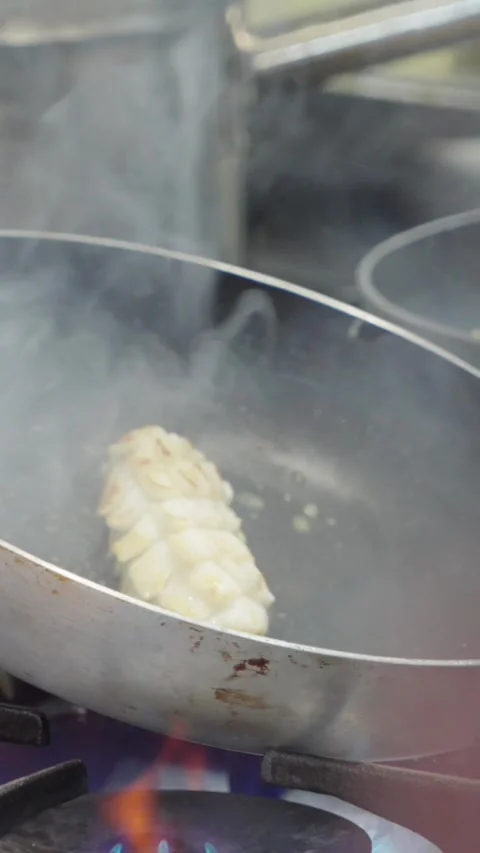 Professional chef working in a commercial kitchen preparing a meal with steam ri Video stock 308972372
