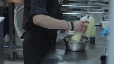 Professional chef working in a commercial kitchen preparing a meal with steam ri Stock Footage 309008633