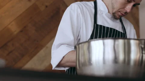 Professional chef working over pots and pans in interior kitchen with soft day l Stock Footage 199461850