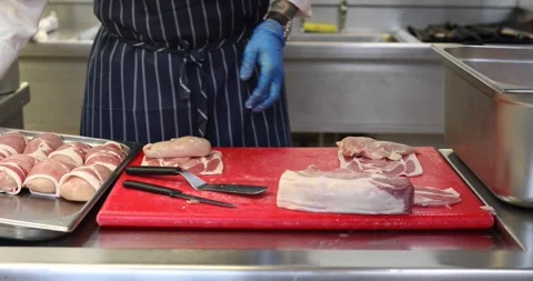 Professional Chef wrapping Chicken in bacon Stock Footage 289411011