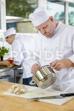Professional chefs makes food dishes in large kitchen Stock Photos