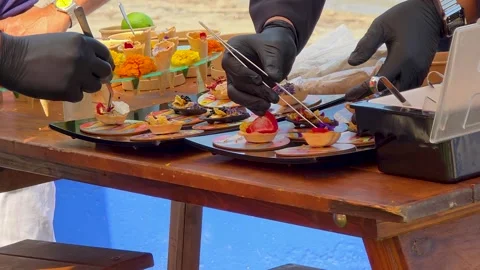 Professional chefs using tweezers to decorate gourmet appetizers and canapes Video stock 347311441
