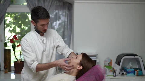Professional chiropractor adjusting a woman's jaw and neck in a clinic Stock Footage 333506873