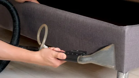 Professional cleaner man using vacuum cleaner to remove dirt steams from sofa. Stock Footage 311801262