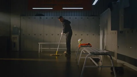 Professional Cleaner Thoroughly Mopping and Disinfecting Sports Dressing Room Stock Footage 338448686