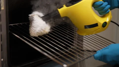 Professional cleaner worker using handheld steam cleaner to eliminate grease and Stock Footage 292692825