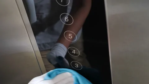 Professional cleaning concept. Disinfecting elevator push buttons with wet Stock Footage 137049429