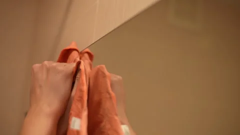 Professional cleaning service worker cleaning bathroom mirror with microfiber Stock Footage 297624079