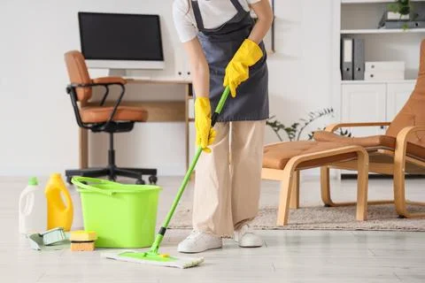 Professional cleaning service worker mopping office floor with cleaning suppl Stock Photos