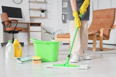 Professional cleaning service worker mopping office floor with green mop and  Stock Photos