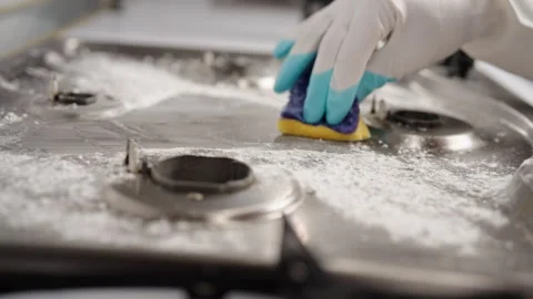 Professional cleaning service worker in rubber gloves cleaning gas stove with Stock Footage 306001079