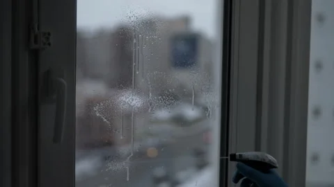 Professional cleaning service worker spraying cleaning solution onto window and Stock Footage 342769094