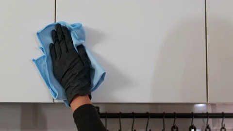 Professional cleaning worker wiping kitchen facade with cloth in simple, modern Video stock 295778894