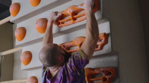 Professional climber performs exercises on training bouldering wall. 1920x1080 Stock Footage 77803546